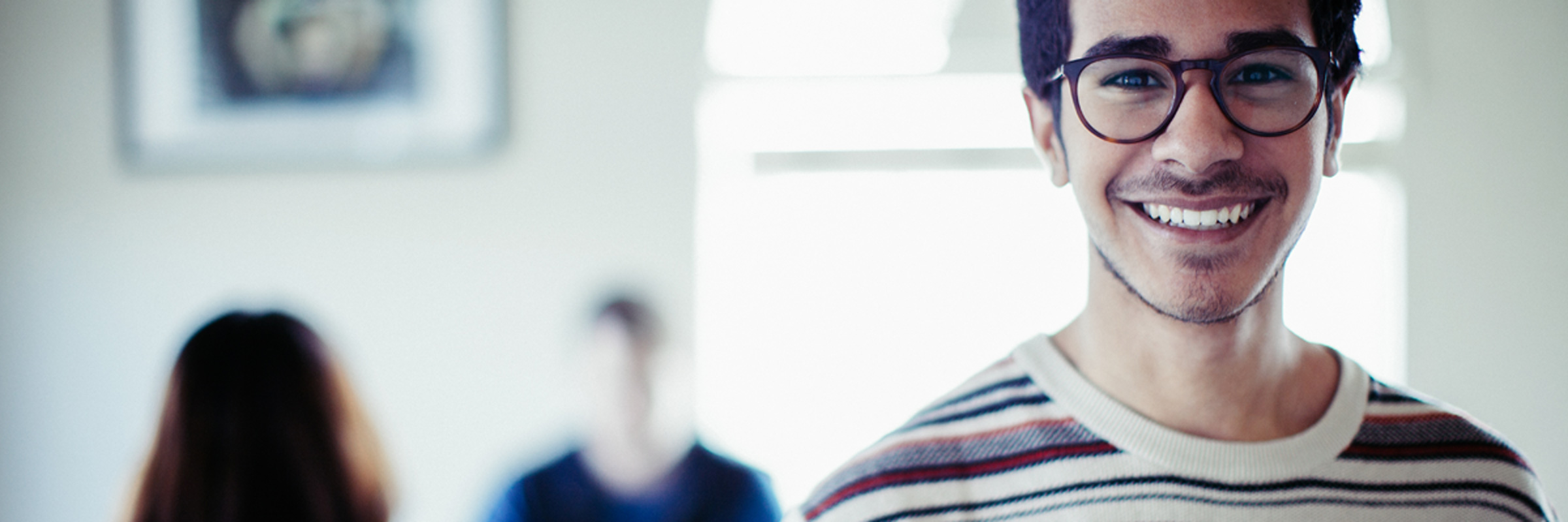 Man looking at camera with workers in background