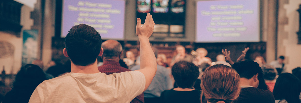 Church worshippers with lyrics projected onto big screens